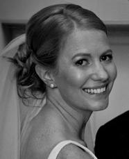 A bride smiling over her shoulder, hair swept up