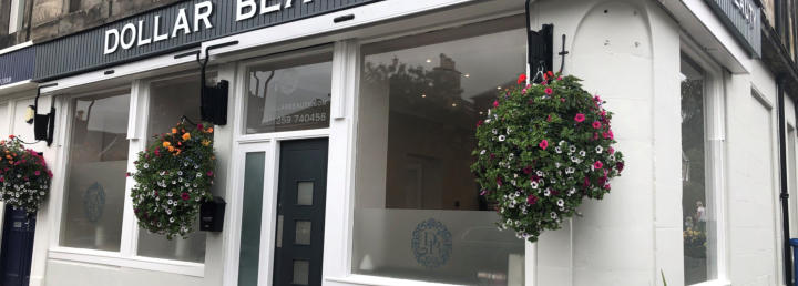 Dollar Beauty shopfront on Bridge Street, navy signage and hanging flower baskets