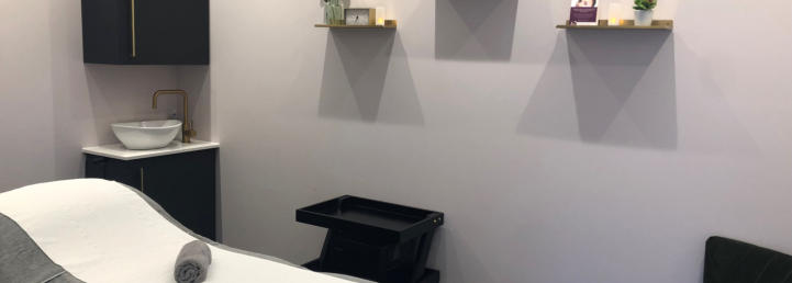 A private treatment room with a treatment bed and basin
